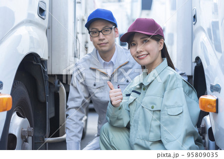 トラックのタイヤを点検する男女のドライバー トラックのタイヤを点検する男女のドライバー 95809035
