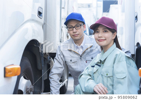 トラックのタイヤを点検する男女のドライバー 95809062