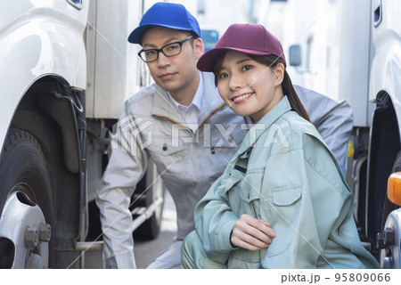 トラックのタイヤを点検する男女のドライバー 95809066