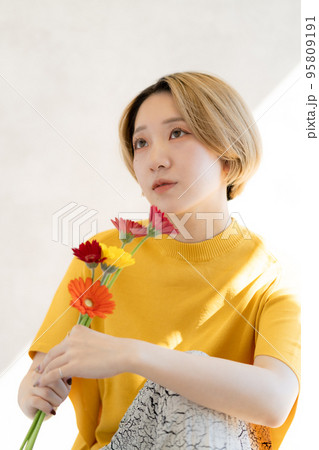 ガーベラを持った若い女性のポートレート 95809191
