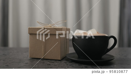 gift box near black cup with hot chocolate on concrete countertop 95810877