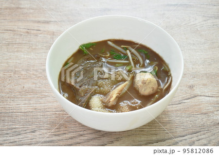 boiled braised beef and meatball in black herb soup on bowl 95812086