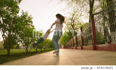 happy family. little girl spinning air. mother circles child by hands. kid superhero. childhood dream fly. play airplane pilot. fantasize game. pretend be pilot. first grader vacation with mom concept 95814605