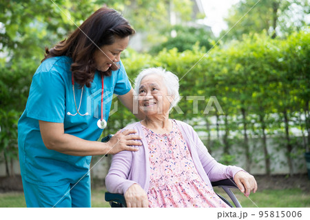 Doctor caregiver help and care Asian senior or elderly old lady woman patient sitting on wheelchair in park at nursing hospital, healthy strong medical concept 95815006