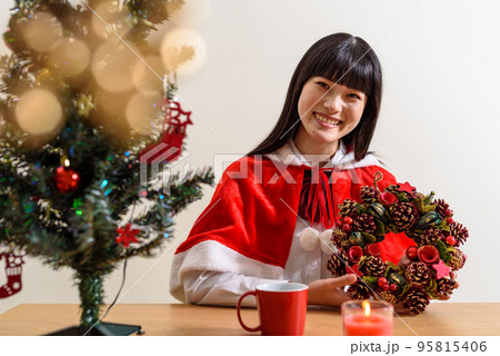 学生服の上にクリスマスの衣装を着て楽しみに笑顔ですごす女子高校生 クリスマスリースを渡す 学生服の上にクリスマスの衣装を着て楽しみに笑顔ですごす女子高校生 クリスマスリースを渡す 95815406