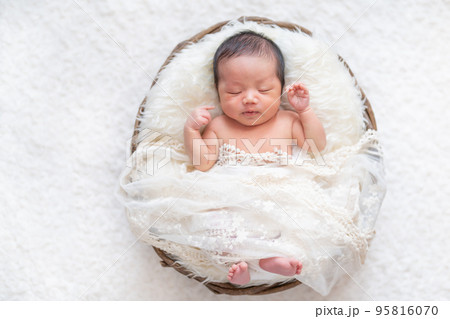 かごの中ですやすや眠る生まれたての赤ちゃん（ニューボーンフォト） 95816070