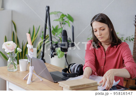 woman in a home office records podcast audio content with a microphone and headphones and a labrador dog woman in a home office records podcast audio content with a microphone and headphones and a labrador dog 95816547