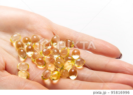Women hand with gel capsules of D Vitamin . Vitamin Omega-3 fish oil in capsules. hand holding gelcap or softgel transparent capsule pills Women hand with gel capsules of D Vitamin . Vitamin Omega-3 fish oil in capsules. hand holding gelcap or softgel transparent capsule pills 95816996