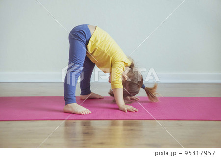 Charming baby doing yoga at home. Place for text 95817957