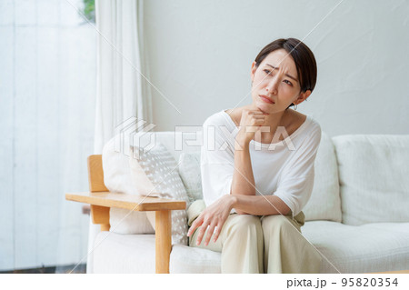 リビングで悩む主婦 95820354