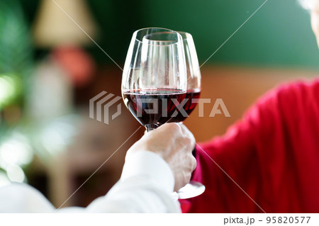 ワインで乾杯をするシニアカップルの手元 95820577