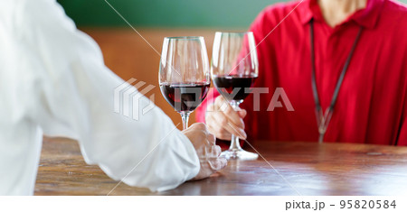 ワインで乾杯をするシニアカップルの手元 95820584
