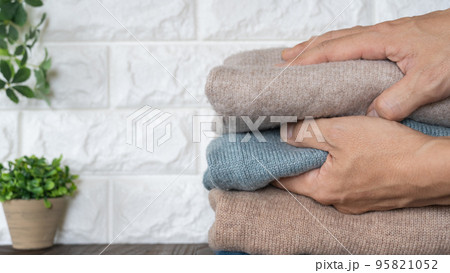 たたまれた冬物の服｜洗濯物・衣替えイメージ 95821052