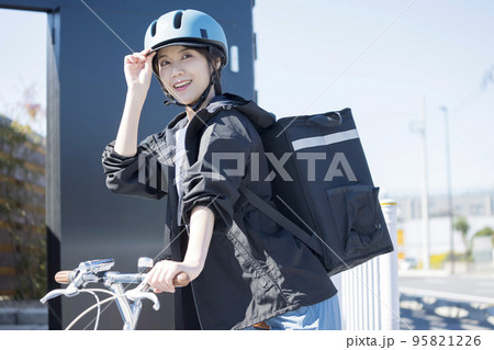 フードデリバリーイメージ　自転車でデリバリーする若い女性 シェアデリ 95821226