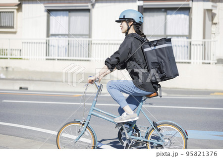 フードデリバリーイメージ　自転車でデリバリーする若い女性 シェアデリ 95821376