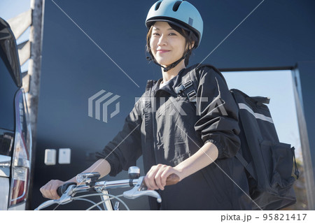 フードデリバリーイメージ　自転車でデリバリーする若い女性 シェアデリ 95821417