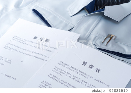 作業服の上に置かれた督促状と催告書 95821619