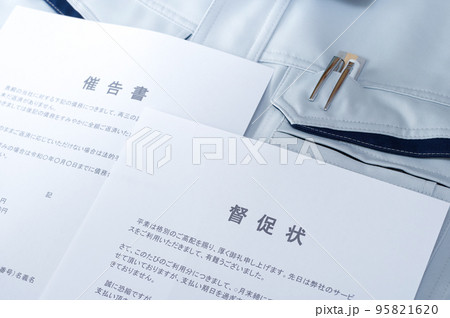 作業服の上に置かれた督促状と催告書 作業服の上に置かれた督促状と催告書 95821620