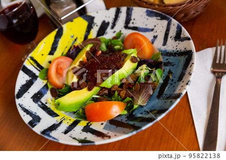 Fresh salad with avocado, raisins and strawberry jam 95822138