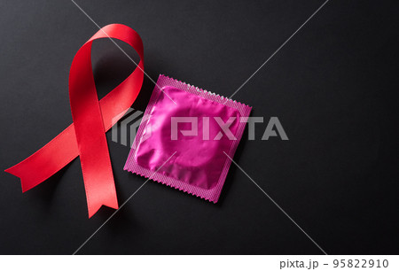 Closeup red ribbon HIV, world AIDS day awareness ribbon on black background. Healthcare and medicine concept. 95822910