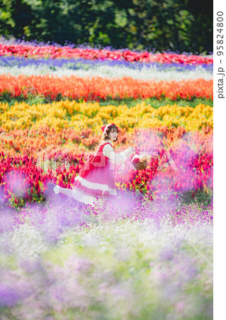 お花畑と赤ずきんちゃんの仮装した女性 95824800