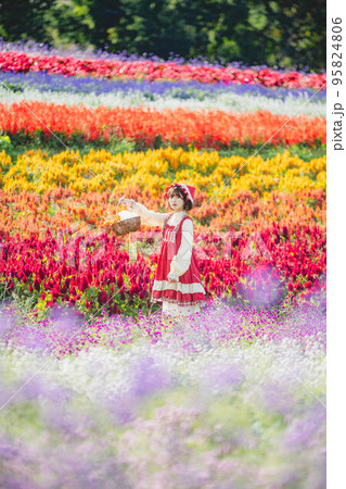 お花畑と赤ずきんちゃんの仮装した女性 95824806