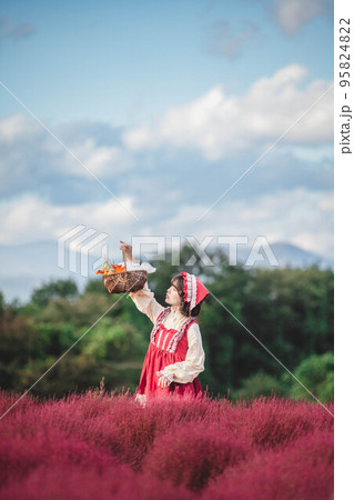 カラフルな花園にいる赤ずきんの仮装をした女性 95824822