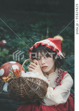 森の中で赤頭巾の仮装をする女性 95824829