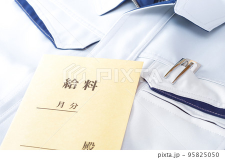 作業服の上に置かれた給料袋 95825050