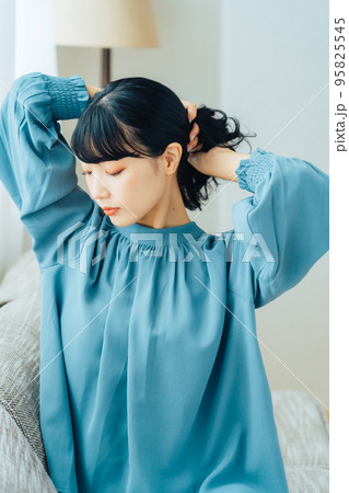 髪を束ねる女性 95825545