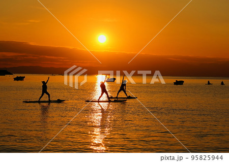夕暮れの逗子海岸、SUPヨガを楽しむ女性たちのシルエット 夕暮れの逗子海岸、SUPヨガを楽しむ女性たちのシルエット 95825944