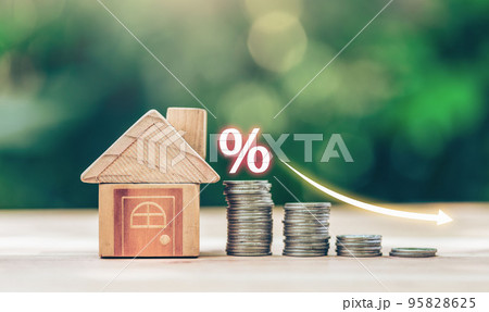 House and coins place on the wood table is ladder with white illustration shows decreasing of interest rates. 95828625