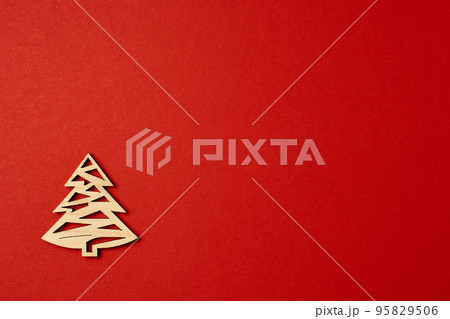 Christmas red background, with wooden Christmas trees. Minimalistic Christmas red background. Christmas background with toys top view on a red background. New Year card. Christmas red background, with wooden Christmas trees. Minimalistic Christmas red background. Christmas background with toys top view on a red background. New Year card. 95829506