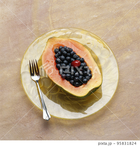papaya with currant on plate papaya with currant on plate 95831824