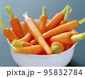 Fresh organic honey glazed baby carrots in a serving bowl 95832784