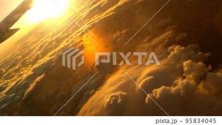 雲の上から撮った夕焼けの空と飛行機の翼 95834045
