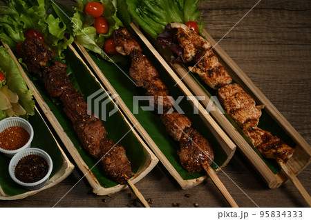 Delicious grilled meat served in bamboo barrel plat. Mala Chinese BBQ is meat or vegetable grilled with Chinese hot and spicy spices Delicious grilled meat served in bamboo barrel plat. Mala Chinese BBQ is meat or vegetable grilled with Chinese hot and spicy spices 95834333