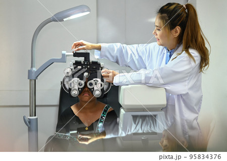 Beautiful female ophthalmologist examining eyesight of child patient with special ophthalmic glasses Beautiful female ophthalmologist examining eyesight of child patient with special ophthalmic glasses 95834376