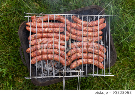 Cooking sausages on the charcoal grill outdoor, Italy. Traditional BBQ with griends outdoor Cooking sausages on the charcoal grill outdoor, Italy. Traditional BBQ with griends outdoor 95838068