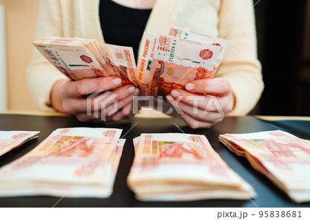 women's hands count a stack of money of a banknotes of 5000 rubles on a black 95838681