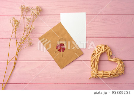 Envelope with letter on pink wooden background top view Envelope with letter on pink wooden background top view 95839252