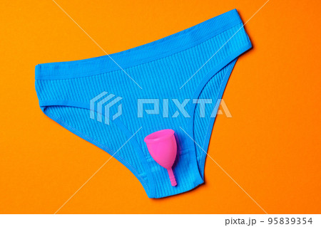 Menstrual cup and panties on paper background. 95839354