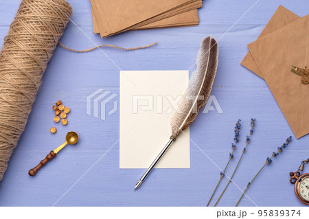 Blank paper with feather and envelopes on lavender wooden table 95839374