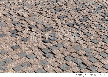 Old street pavement made of square stone blocks Old street pavement made of square stone blocks 95839423