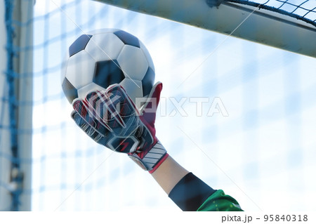 サッカーボールをキャッチするゴールキーパーの男性 95840318