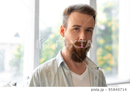 Bearded smiling handsome young man standing alone at home 95840714