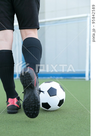 サッカーボールを蹴るゴールキーパーの男性 95842589