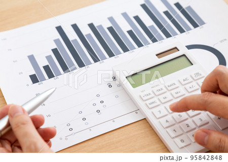 グラフ資料を見るミドル女性の手元 95842848