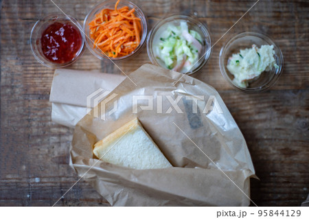 テーブルの上に並べられたテイクアウト用のサンドウィッチと野菜 95844129