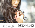 黒髪ロングの髪を触っている女性の手のクローズアップ 95844142